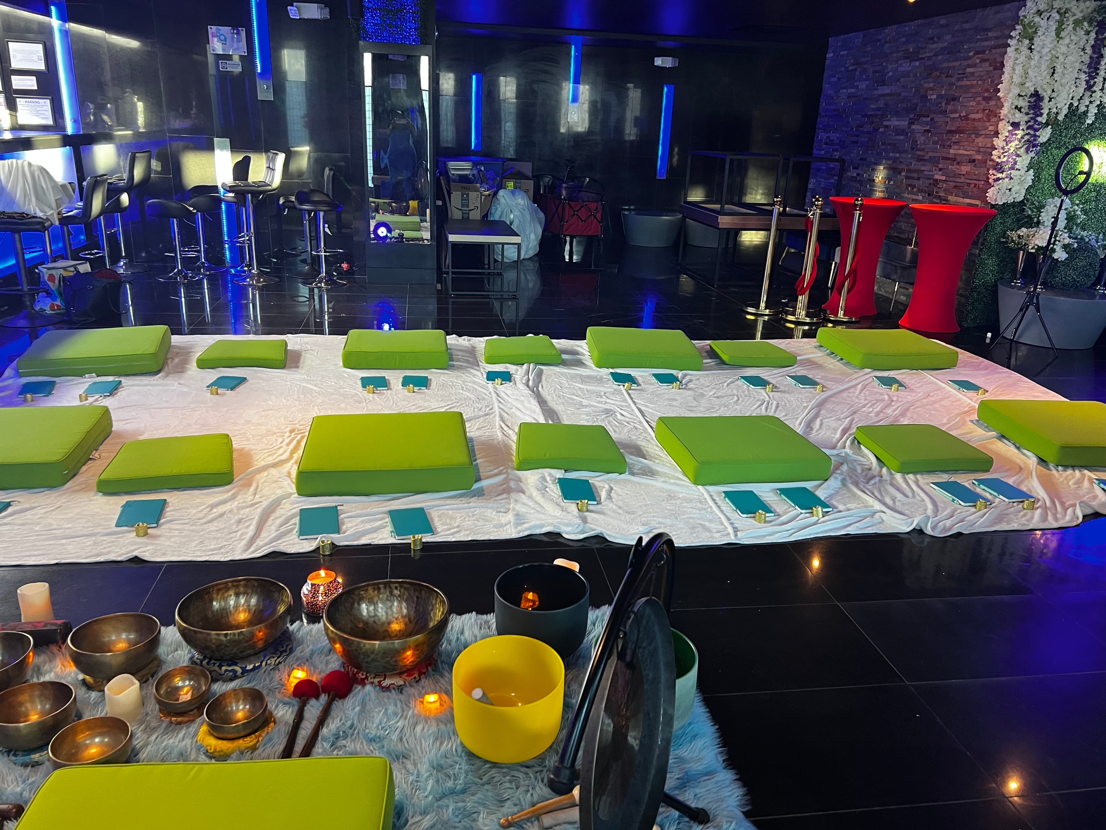Community wellness floor setup with meditation cushions and sound bowls